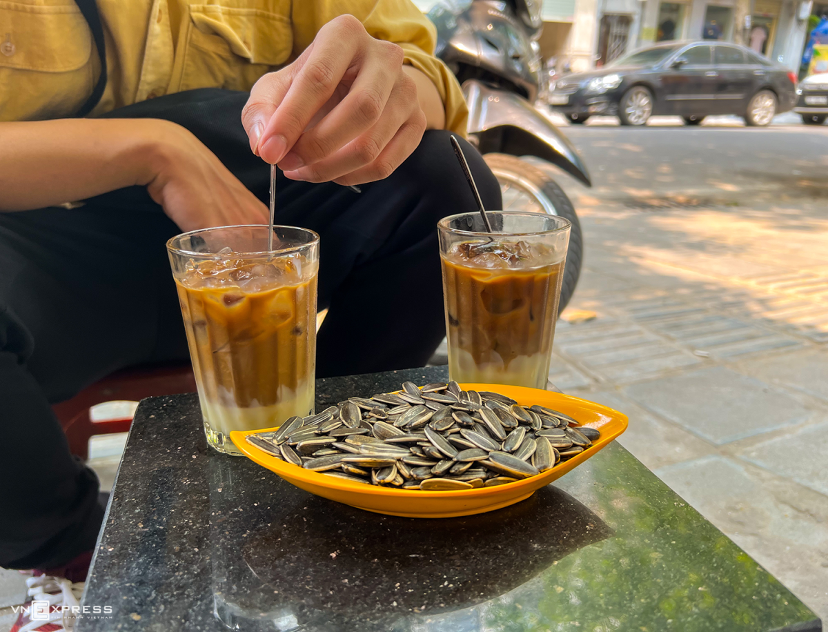 Uống cà phê sữa đá, cắn hạt hướng dương là một văn hóa đường phố của người Việt. Ảnh: Trung Nghĩa