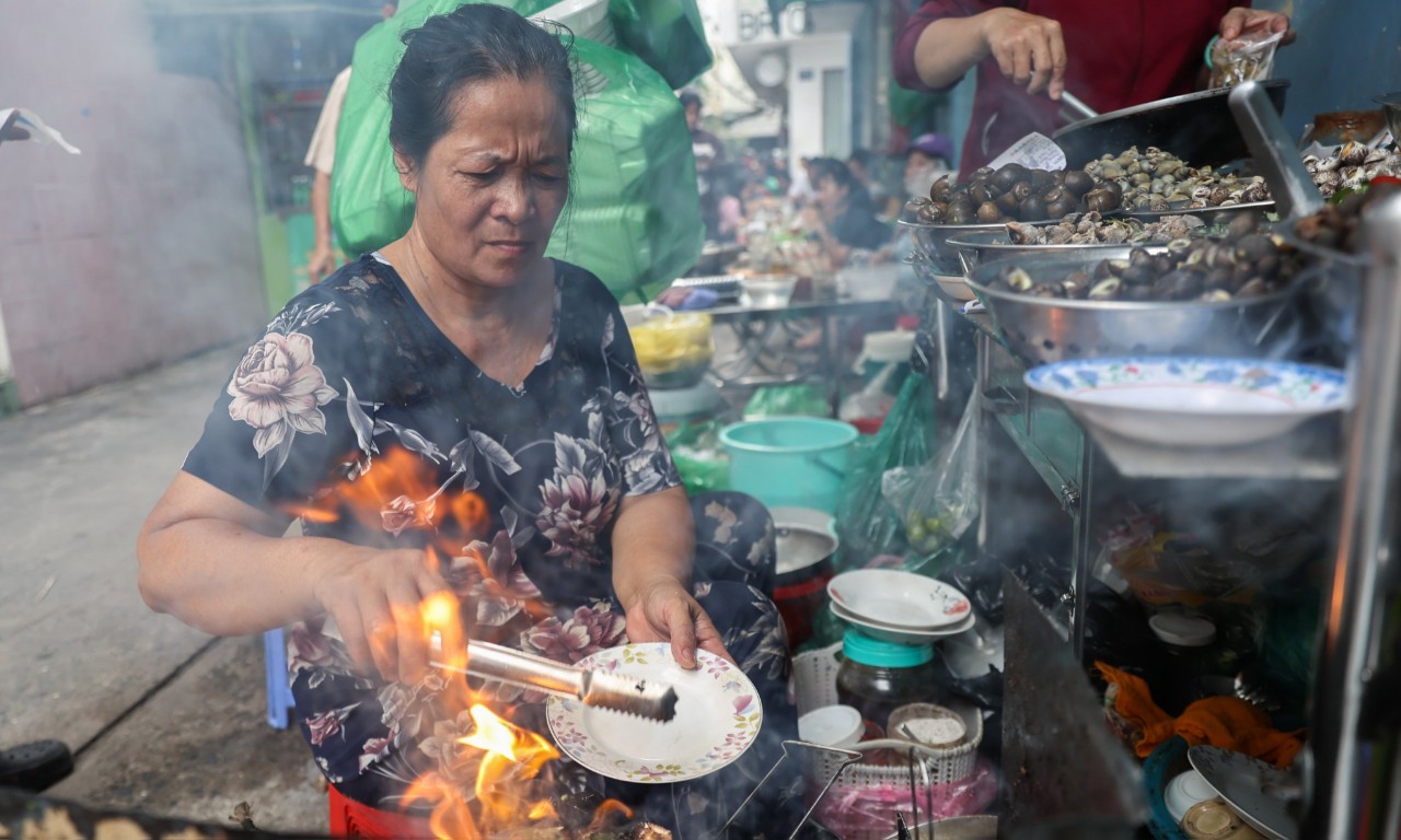 Bà Phượng, chủ quán ốc, đang chế biến món cho khách.