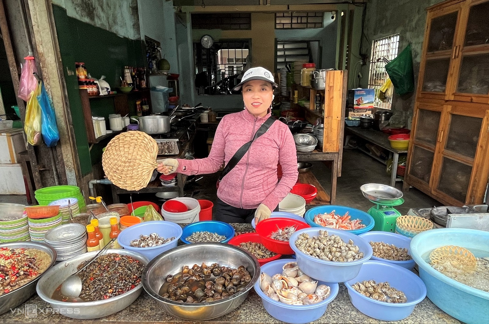 Chị Nhưng và hàng ốc tươi sống của mình, một số loại được bỏ trong nước, thở oxi. Ảnh: Huỳnh Nhi